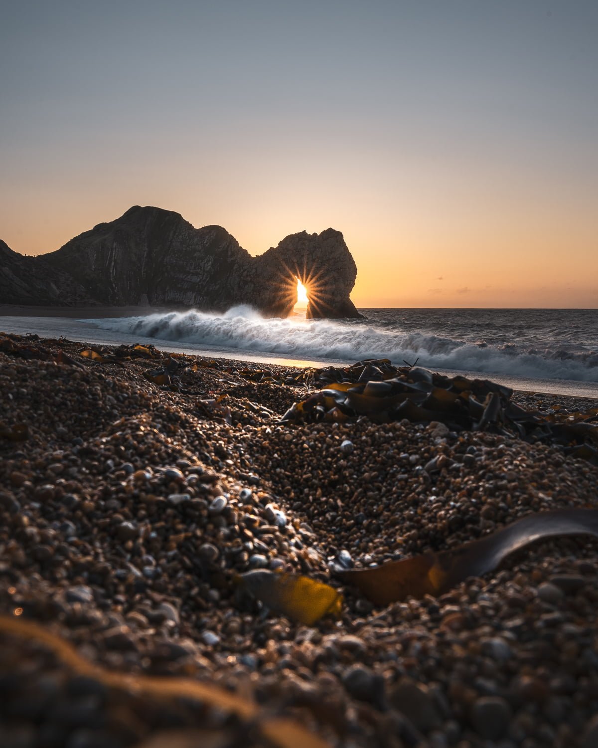 durdle door sunrise through arch