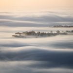 Layers of mist rolls across the Somerset Levels, viewed from Crook Peak