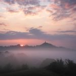 A beautiful pastel-coloured misty sunrise looking towards Glastonbury Tor